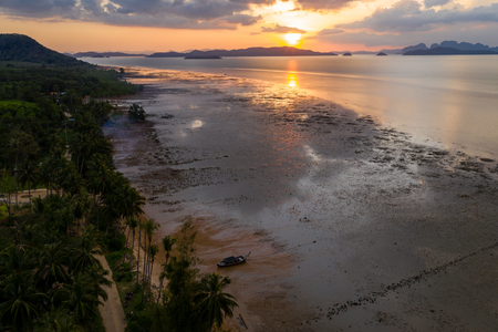 Aerial view of a colorful tropical sunset over a beach and calm oceanの写真素材