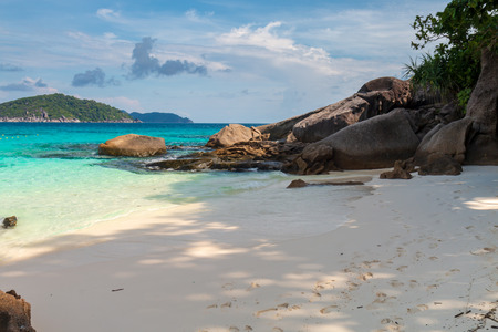 A beautiful, empty sandy beach on a tropical island, surrounded by clear, warm ocean