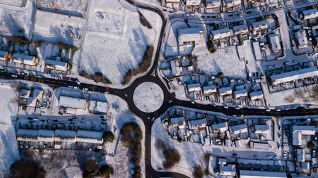 Aerial drone view of a traffic roundabout surrounded by fresh snowfall (Ebbw Vale, Wales, UK)の写真素材