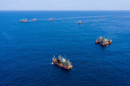Aerial drone view of a fleet of industrial fishing trawlers in a tropical oceanのeditorial素材