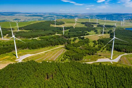 Aerial drone view of a large onshore windfarm on a green hillsideの写真素材