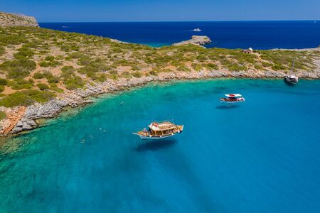 Aerial drone view of traditional Greek wooden boats floating on the crystal clear waters of the Aegean Sea (Crete)の写真素材