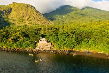 Aerial drone view of beautiful evening light and clouds on volcanos on a tropical island (Camiguin,...