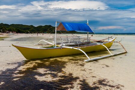Small wooden boats on a tropical beach in the Philippinesの写真素材