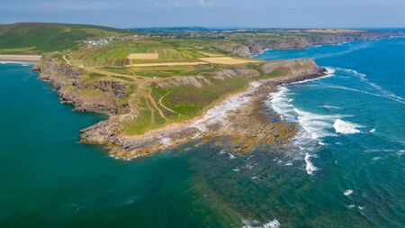 Aerial drone view of waves breaking onto sea cliffs on a summers day