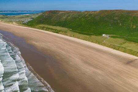 Aerial drone view of the beautiful, huge sandy beach at Rhossili on the Gower Peninsula in Wales