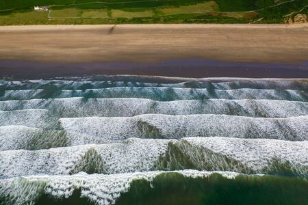 Aerial drone view of the beautiful, huge sandy beach at Rhossili on the Gower Peninsula in Walesの写真素材