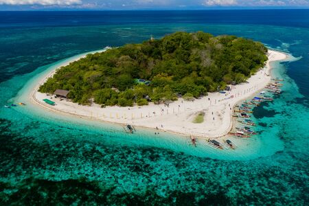 Aerial drone view of a beautiful tropical island and surrounding coral reefの写真素材