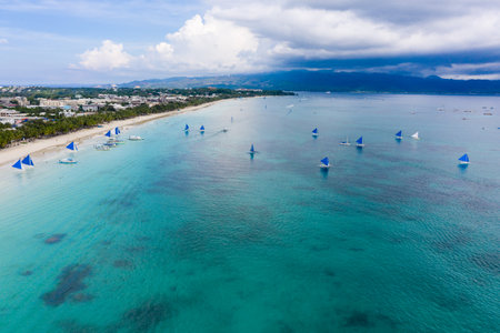 Boracay, PHILIPPINES - 17 JUNE 2019: Sailing boats on the ocean next to White Beach on the...