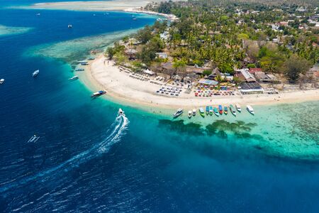 Aerial view of boats moored off a beautiful tropical coral reef and beach on a small island (Gili Air, Indonesia)の写真素材