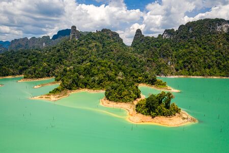 Aerial view looking downwards onto tiny islands and fingers of tropical rainforest covered land in a huge lakeの写真素材