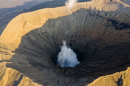 Aerial view of an active volcanic crater venting gas and steam at duskの写真素材