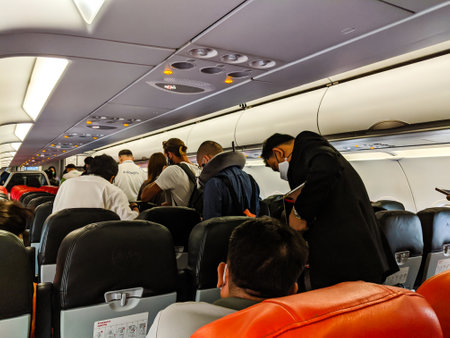 BANGKOK, THAILAND - JUNE 05 2020: Passengers wearing masks queue to disembark a domestic Air Asia flight to Bangkok. Thailand has resumed domestic flights following the Coronavirus pandemic with airlines introducing mandatory mask rules,lower capacity andのeditorial素材