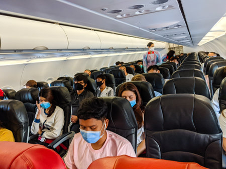 BANGKOK, THAILAND - JUNE 05 2020: Passengers on board a domestic Air Asia flight to Bangkok following the resumption of domestic flights during the coronavirus pandemic. Airlines have introduced social distancing measures such as mandatory facemasks, no mのeditorial素材