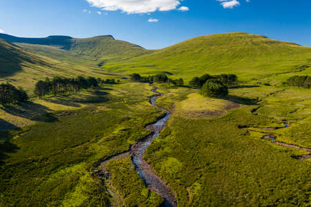 Aerial view of a river running from distant mountains (Pen-y-Fan, Brecon Beacons, Wales)