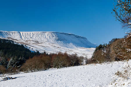 Snow covered mountains on a bright, sunny day (Neuadd Reservoir, Wales)の写真素材