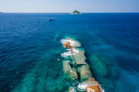 Aerial view of a SCUBA diving boat moored above a clear, tropical coral reef in Thailand's Similan Islands.の写真素材