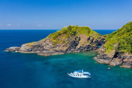 Aerial drone view of boats around a beautiful, remote tropical island in a blue oceanの写真素材