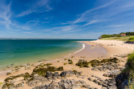 A large sandy beach and shallow sea on Caldey Island, Wales, UKの写真素材
