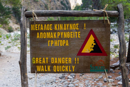 A sign warning of "Great Danger" advising people to "Walk Quickly" due to falling rocksの写真素材