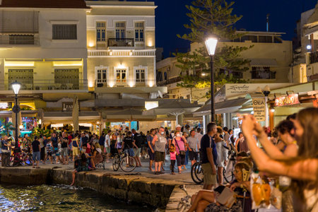 CHANIA, CRETE - JULY 17 2021: Crowds of tourists in the ancient Venetian harbour in Chania on the Greek island of Crete at night.のeditorial素材