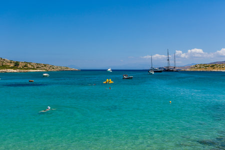MARATHI, CRETE - 18 JULY 2021: Locals and tourists relaxing on the beach at Marathi on the Chania peninsula of Creteのeditorial素材