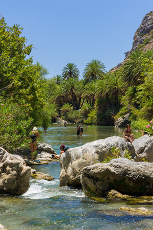 PREVELI, CRETE - JULY 21 2021: Crowds of people exploring the natural palm forest and sandy beach at Preveli on the southern coast of the Greek island of Crete.のeditorial素材
