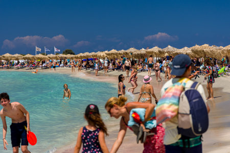 ELAFONISI, CRETE - JULY 19 2021: Crowds of tourists on the picturesque beach and shallow lagoons at...
