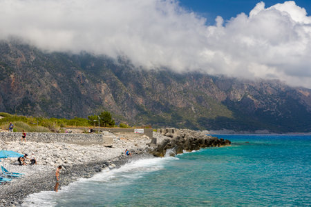 AGIA ROUMELLI, CRETE - 20 JULY 2021: Tourists relaxing on the rocky beach in the village of Agia Roumelli near the exit of the Samaria Gorge on the island of Creteのeditorial素材