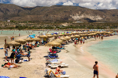ELAFONISI, CRETE - JULY 19 2021: Crowds of tourists on the picturesque beach and shallow lagoons at Elafonissi on the Greek island of Crete.のeditorial素材