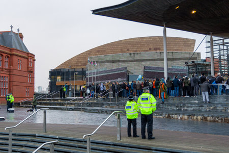 CARDIFF, WALES - NOVEMBER 09 2021: Officers from South Wales Police observe a demonstration against covid vaccine passports on the steps of the Welsh Parliament in Cardiff, Walesのeditorial素材