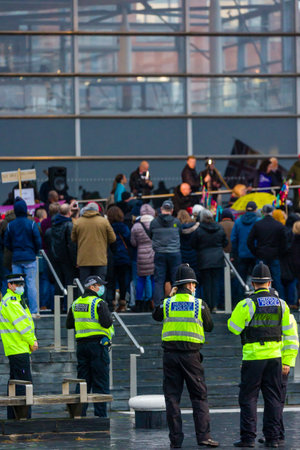 CARDIFF, WALES - NOVEMBER 09 2021: Officers from South Wales Police observe a demonstration against covid vaccine passports on the steps of the Welsh Parliament in Cardiff, Walesのeditorial素材