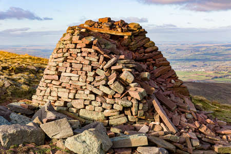 A small hilltop cairn overlooking rural farmland and hills (Carn Pica, Brecon Beacons,Wales)