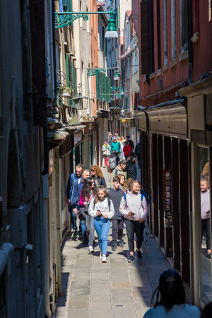 VENICE, ITALY - MARCH 27 2022: Crowds of tourists on a traditional, narrow street in the Italian city of Veniceのeditorial素材