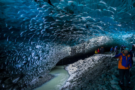 JOKULSARLON,ICELAND - NOVEMBER 18 2021: Tourists exploring the inside of a spectacular ice cave under the VatnajÃ¶kull glacier in southern Icelandのeditorial素材