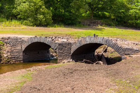 A normally submerged old bridge at a near empty reservoir during a heatwave (Llwyn Onn, Wales)