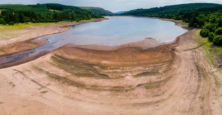 Aerial view of extremely low water levels at a reservoir during a summer heatwave (Llwyn Onnm Wales)の写真素材