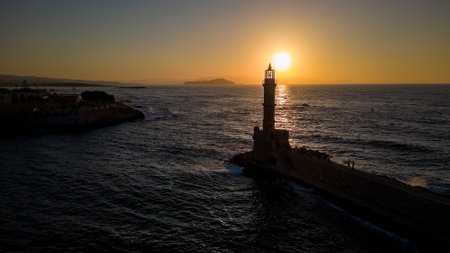 Sunset behind an old stone lighthouse in the Greek town of Chania, Creteの写真素材