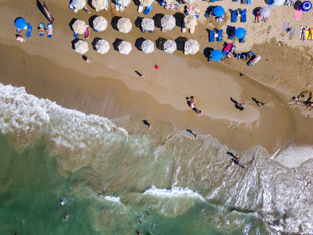 Top down aerial view of a busy beach with sun umbrellas (Nea Chora, Chania, Crete)の写真素材