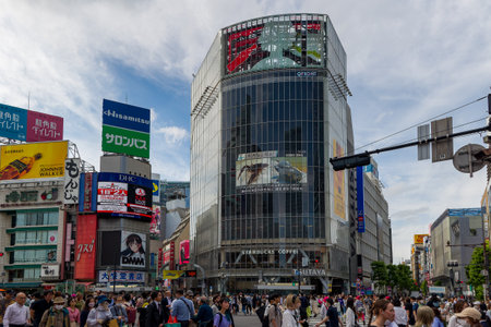 TOKYO, JAPAN - JUNE 21 2023: Large crowds using the famous Shibuya Crossing in a busy shopping area...