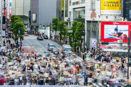 TOKYO, JAPAN - JUNE 21 2023: Long exposure single image of crowds using the famous Shibuya Crossing in Tokyo, Japan.のeditorial素材