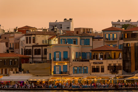 CRETE, GREECE - JULY 03 2023: Crowds of tourists gather at restaurants in the evening around the old Venetian harbour of Chania, western Creteのeditorial素材