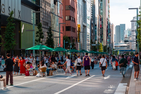 TOKYO, JAPAN - JULY 30 2023: Shoppers on the closed roads of Ginza, the luxury retail district of...