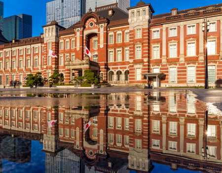 Beautiful reflection of the red brick Tokyo Station in water sprayed to cool the path in the middle of summerの写真素材