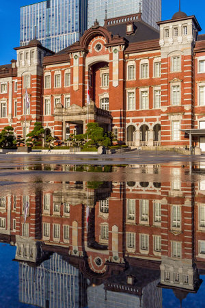 Beautiful reflection of the red brick Tokyo Station in water sprayed to cool the path in the middle of summerの写真素材