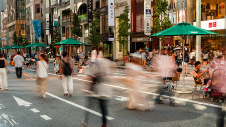 TOKYO, JAPAN - JULY 30 2023: Long exposure motion blurred image of shoppers in the high-end shopping...