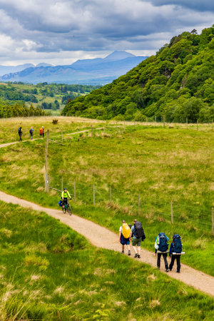 LOCH LOMOND, UNITED KINGDOM - MAY 31 2022: Hikers and walkers on the West Highland Way long distance route heading towards Loch Lomond in the Troassachs national park.のeditorial素材