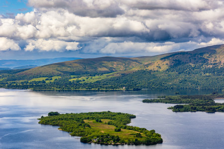 Beautiful Scottish Loch (Lake) with islands surrounded by mountains and a dramatic sky (Loch Lomond, Highlands)の写真素材
