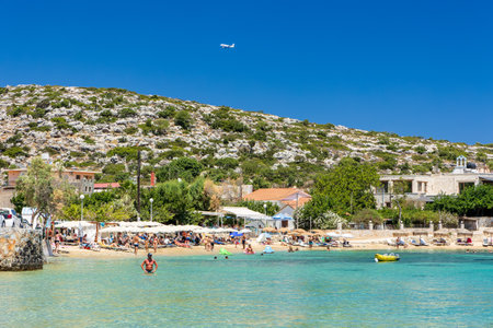 CRETE, GREECE - JULY 01 2023: Swimmers and paddleboarders in the beautiful, clear, shallow waters of Marathi, Chania, Creteのeditorial素材