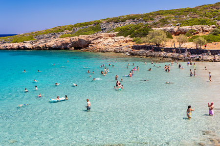 CRETE, GREECE - JULY 12 2023: Swimmers enjoying the warm, crystal clear waters around Kolokitha, near Elounda in Lasithi, Creteのeditorial素材